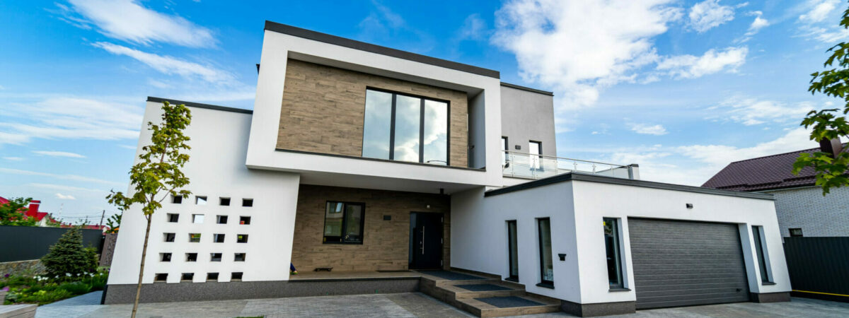 Modern luxury house with garage. Blue sky above. Nobody in the yard. Modern arhitecture.